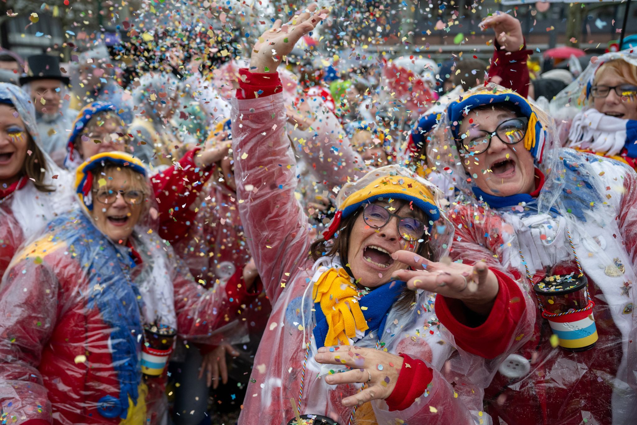 Narren feiern Weiberfastnacht mit Schirm und Regenjacke